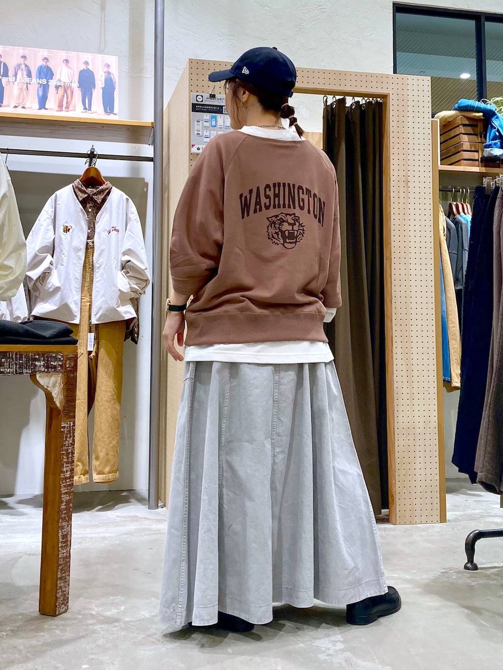 グレー系のスカート、ホワイト系のTシャツ/カットソー、シルバー系のピアス（両耳用）を着用したレディースの春コーディネートの2枚目の写真