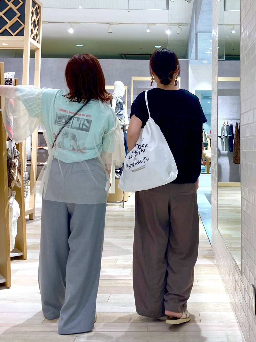 ブラック系のショルダーバッグ、ホワイト系のTシャツ/カットソー、ブラック系のTシャツ/カットソーを着用したレディースの夏コーディネートの5枚目の写真