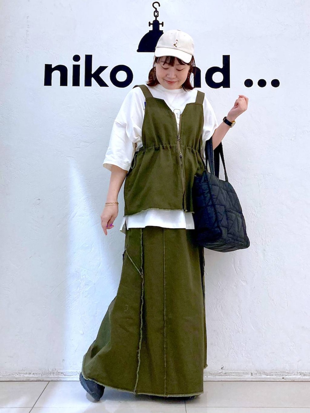 ブラック系のトートバッグ、ホワイト系のTシャツ/カットソー、ゴールド系のブレスレットを着用したレディースの春コーディネートの2枚目の写真