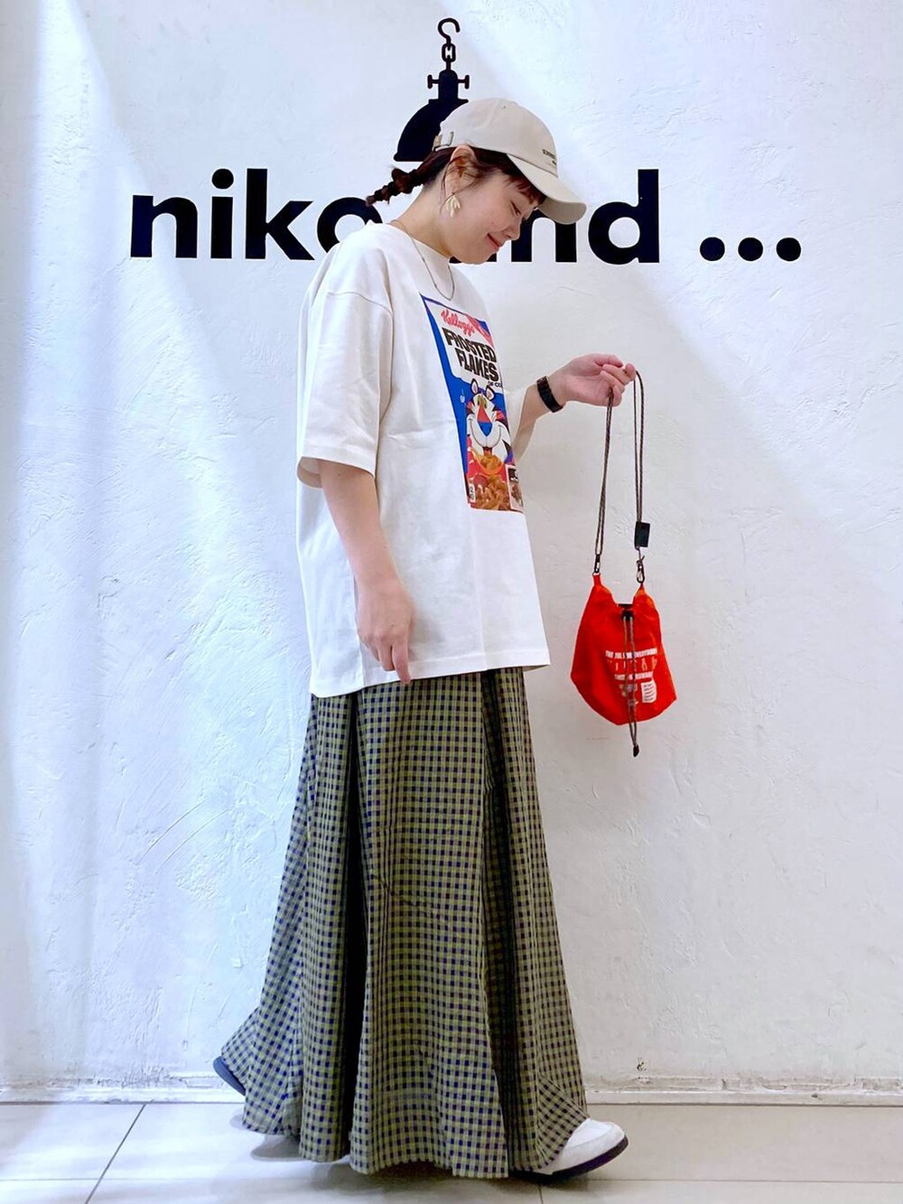 ホワイト系のスニーカー、オレンジ系のショルダーバッグ、ホワイト系のTシャツ/カットソーを着用したレディースの春コーディネートの5枚目の写真
