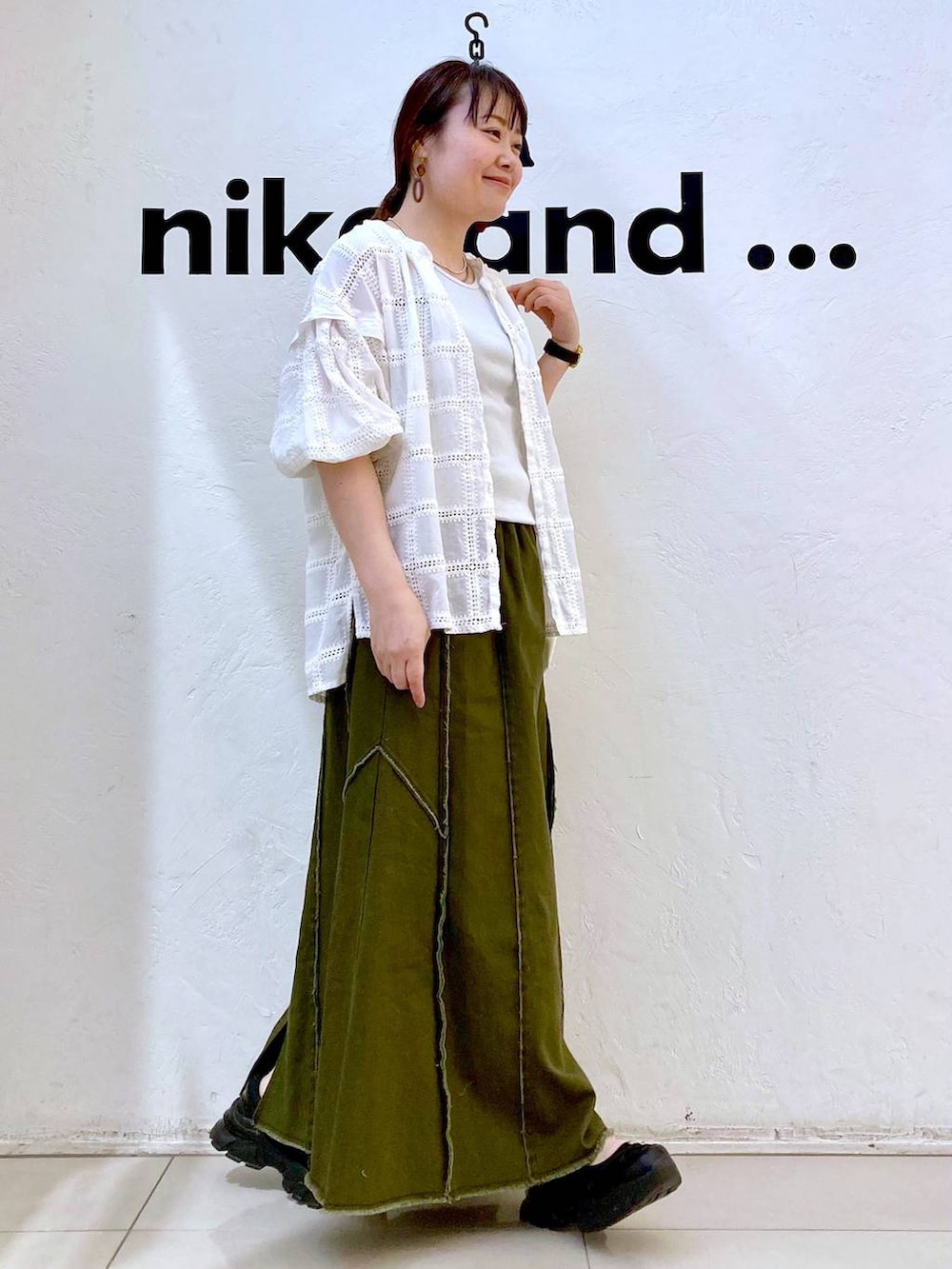 グレー系のタンクトップ、ベージュ系のトートバッグ、ブラック系のスニーカーを着用したレディースの春コーディネートの4枚目の写真