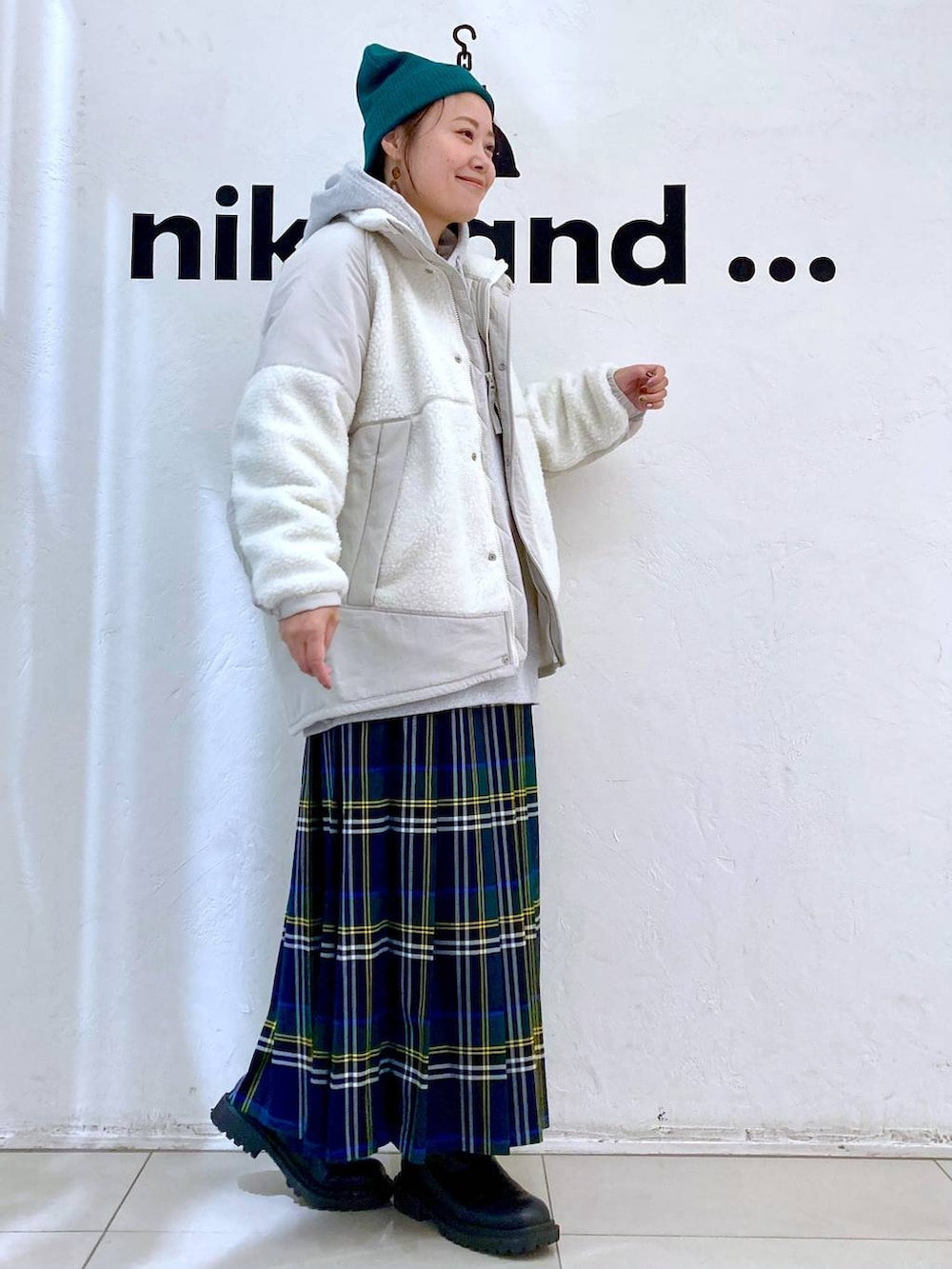 グレー系のパーカー、ベージュ系のブルゾン、ブラウン系のスカートを着用したレディースの秋コーディネートの5枚目の写真