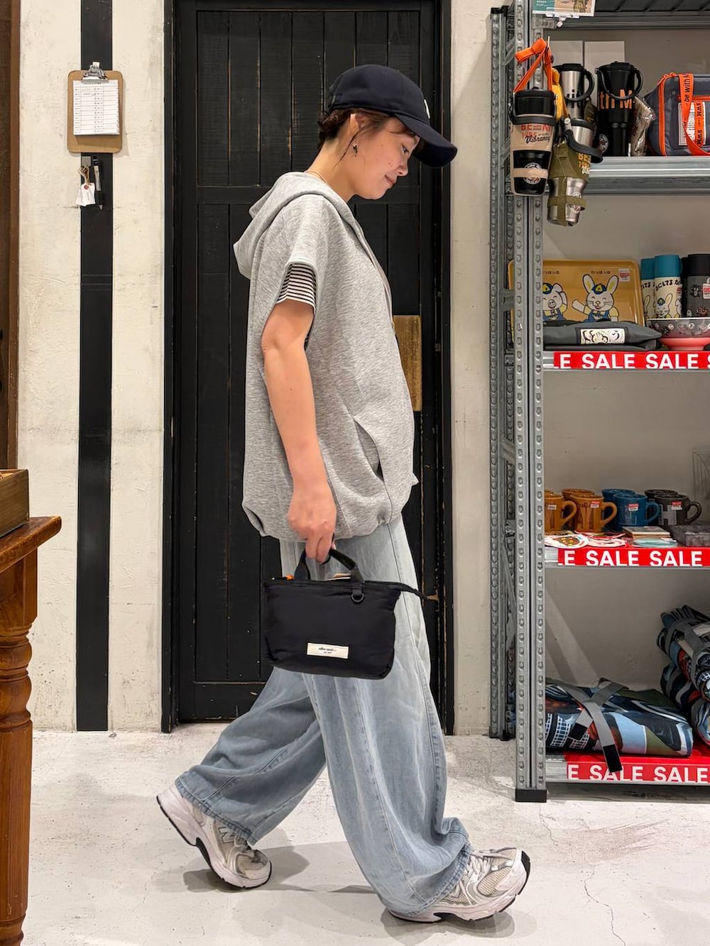 ブラック系のトートバッグ、その他のベスト、ベージュ系のTシャツ/カットソーを着用したレディースの夏コーディネートの5枚目の写真