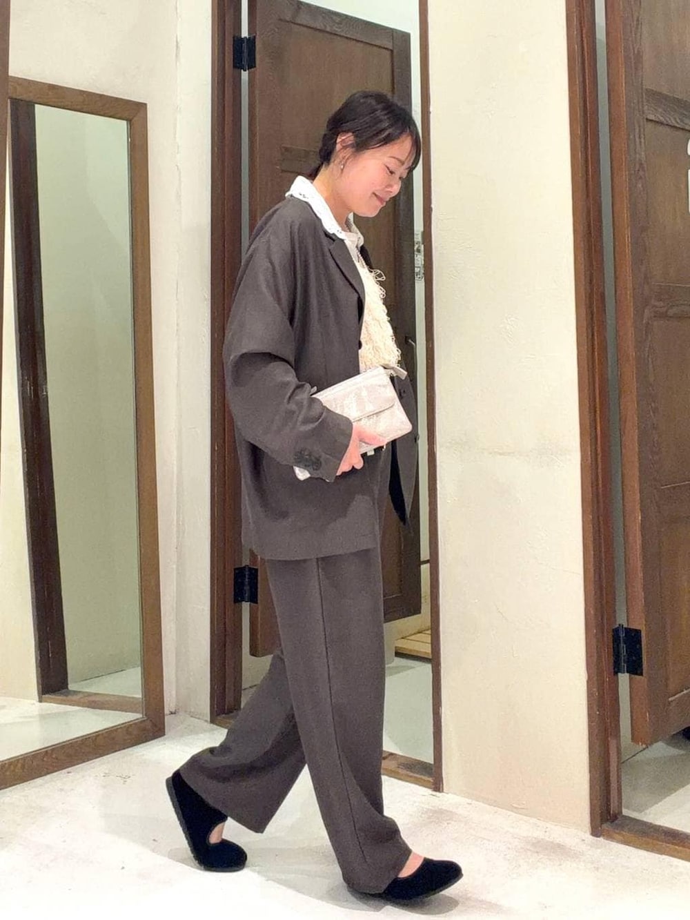 グレー系のショルダーバッグ、ブラック系のパンプス、ブラウン系のテーラードジャケットを着用したレディースの冬コーディネートの6枚目の写真