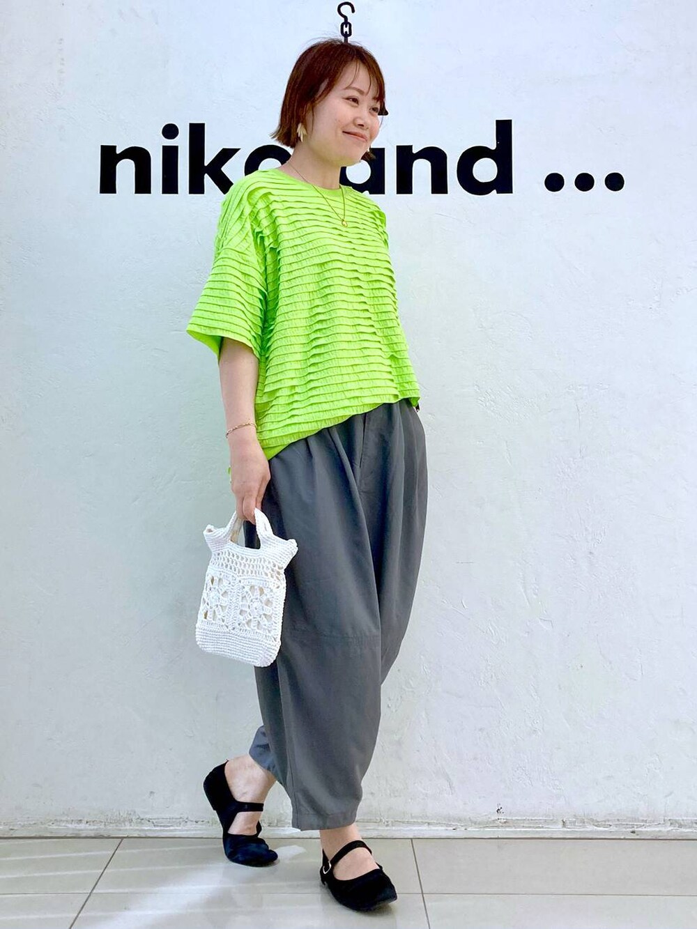 ホワイト系のショルダーバッグ、グリーン系のTシャツ/カットソー、グレー系のその他パンツを着用したレディースの春コーディネートの5枚目の写真