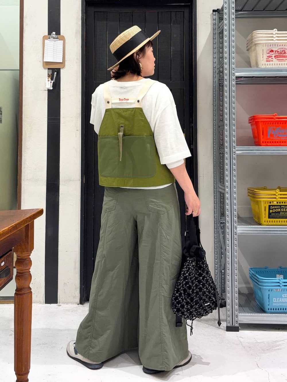 ブラック系のトートバッグ、グリーン系のその他パンツ、ホワイト系のTシャツ/カットソーを着用したレディースの春コーディネートの4枚目の写真