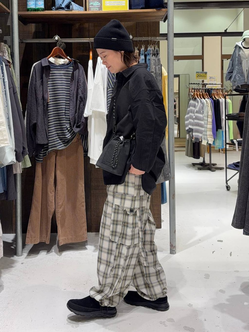 ブラック系のショルダーバッグ、ブラック系のその他シューズ、ホワイト系のTシャツ/カットソーを着用したレディースの春コーディネートの5枚目の写真