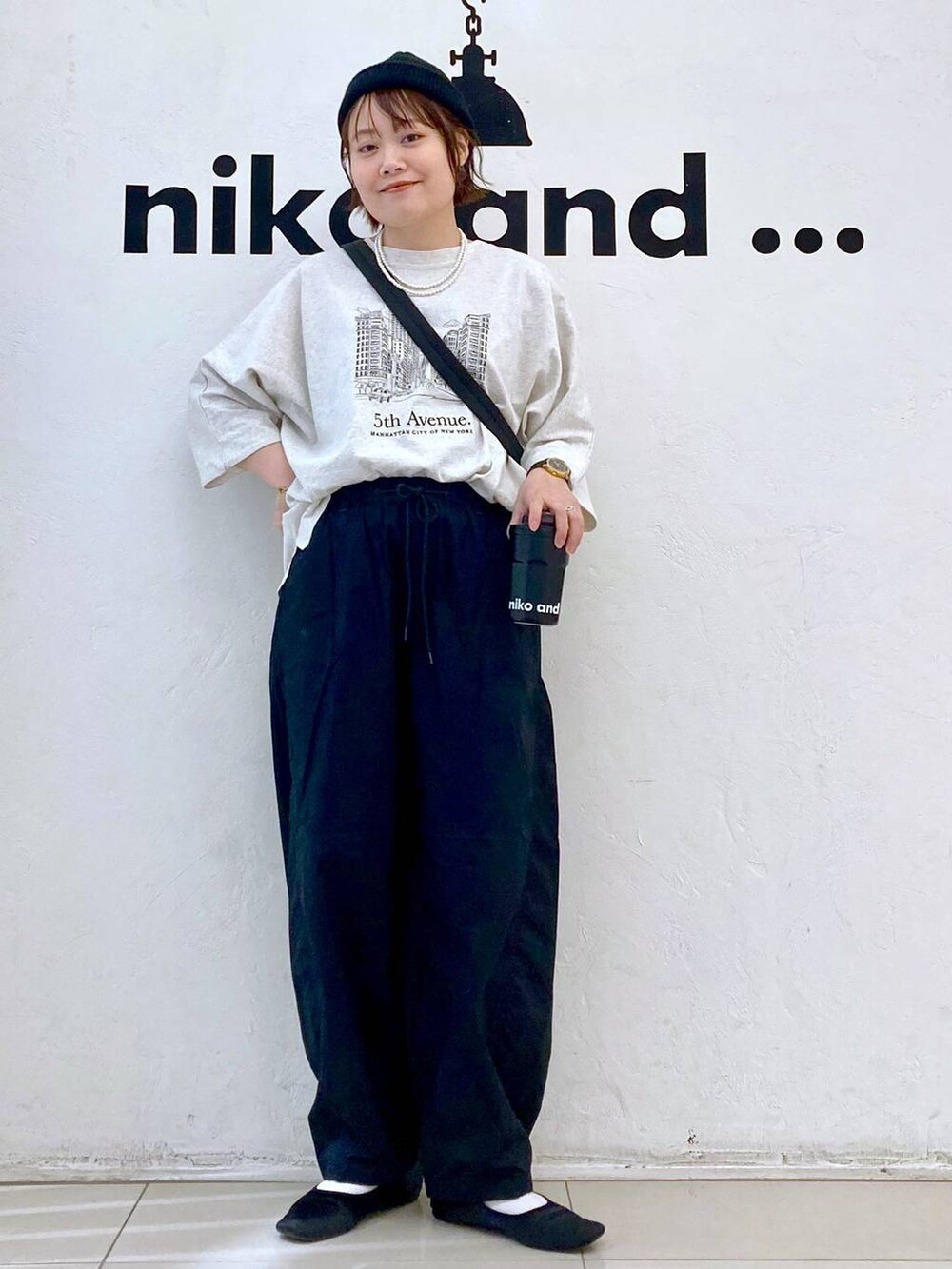 ベージュ系のTシャツ/カットソー、ブラック系のショルダーバッグ、ブラック系のその他パンツを着用したレディースの春コーディネートの2枚目の写真