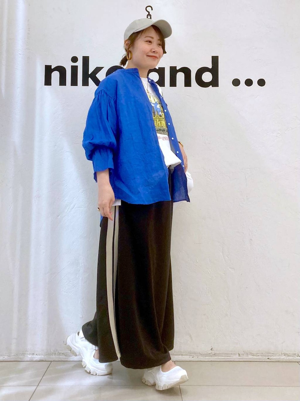 ベージュ系のバックパック/リュック、ホワイト系のTシャツ/カットソー、グレー系のスカートを着用したレディースの春コーディネートの3枚目の写真