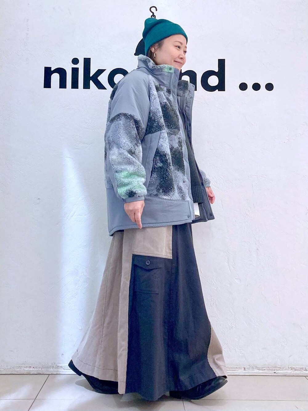 グレー系のブルゾン、ホワイト系のTシャツ/カットソー、グレー系のニット/セーターを着用したレディースの冬コーディネートの5枚目の写真