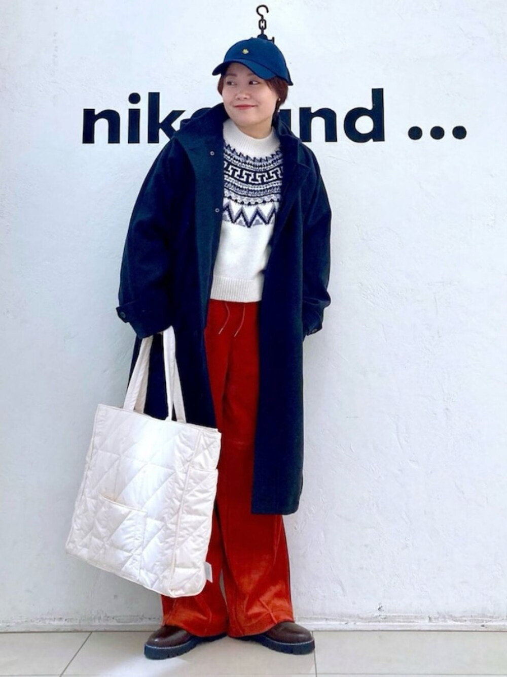 ブラック系のジャケット/アウター、ホワイト系のニット/セーター、レッド系のその他パンツを着用したレディースの冬コーディネートの2枚目の写真