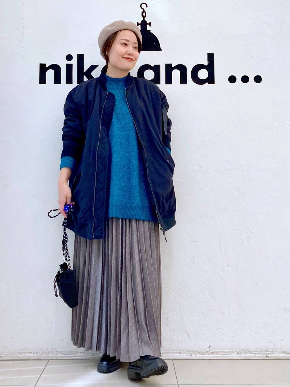 ブラック系のMA-1、グリーン系のニット/セーター、ブラック系のブーツを着用したレディースの冬コーディネートの5枚目の写真