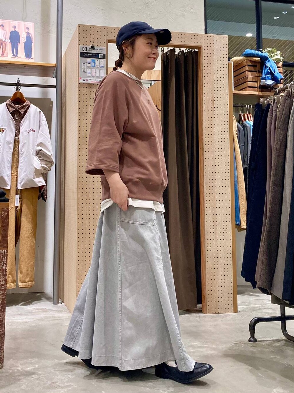 グレー系のスカート、ホワイト系のTシャツ/カットソー、シルバー系のピアス（両耳用）を着用したレディースの春コーディネートの5枚目の写真