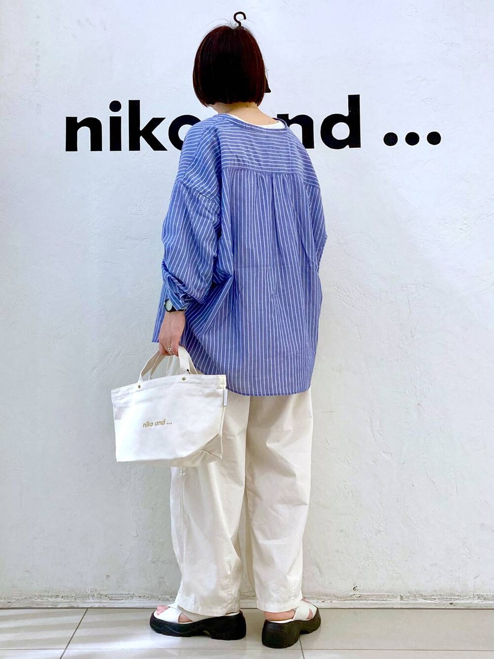 ホワイト系のサンダル、ベージュ系のTシャツ/カットソー、ホワイト系のトートバッグを着用したレディースの春コーディネートの4枚目の写真