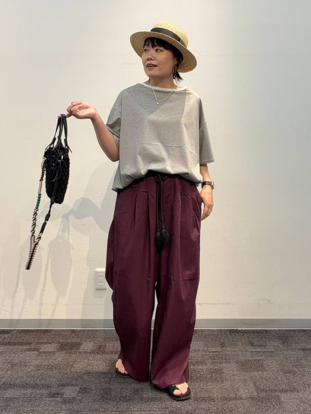 レッド系のその他パンツ、ブラック系のトートバッグ、ホワイト系のTシャツ/カットソーを着用したレディースの夏コーディネートの2枚目の写真