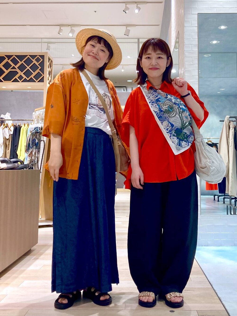 ブルー系のその他パンツ、レッド系のシャツ/ブラウス、ブラック系のサンダルを着用したレディースの春コーディネートの2枚目の写真
