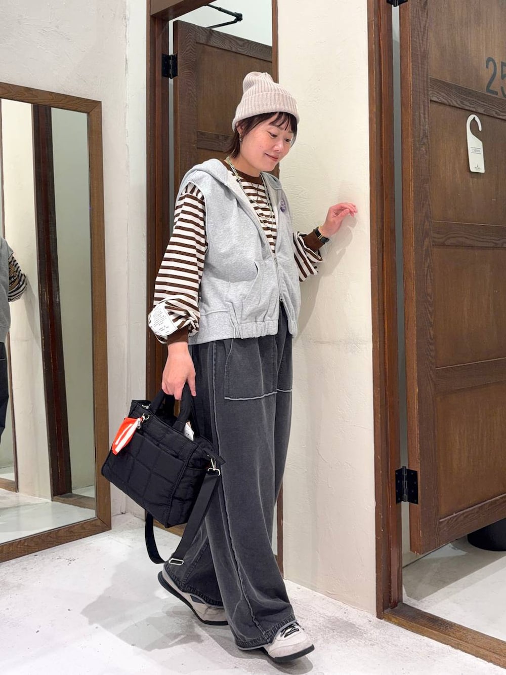 ブラック系のトートバッグ、グレー系のベストを着用したレディースの冬コーディネートの4枚目の写真