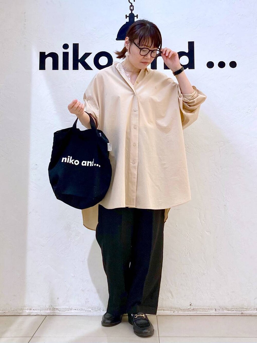 ブラック系のトートバッグ、ブラック系のその他パンツ、ベージュ系のシャツ/ブラウスを着用したレディースの春コーディネートの2枚目の写真