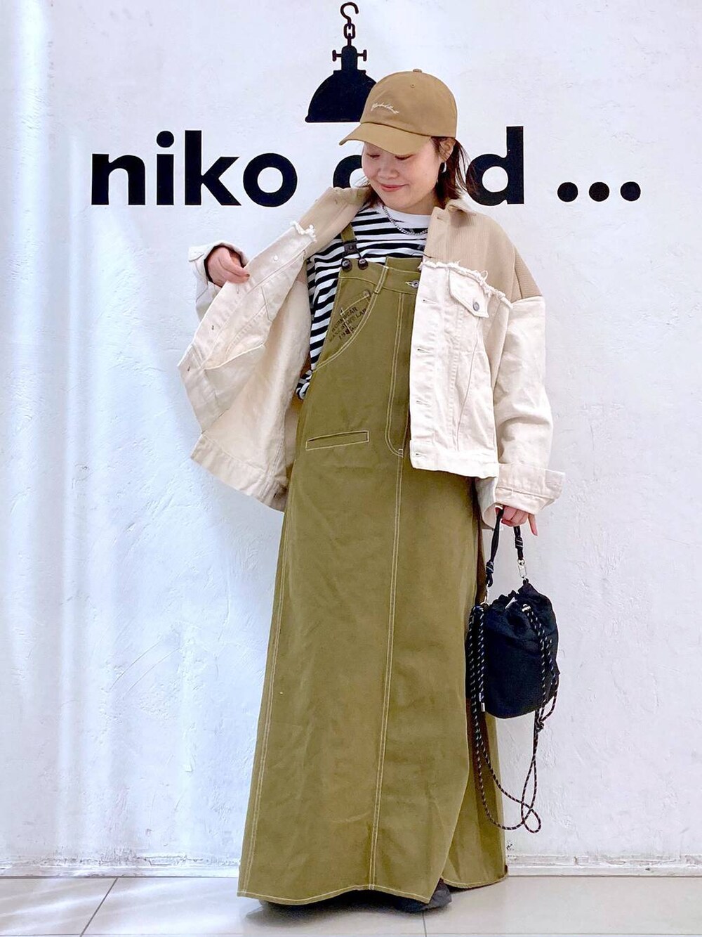 ベージュ系のデニムジャケット、ブラック系のショルダーバッグ、シルバー系のピアス(両耳用)を着用したレディースの冬コーディネートの2枚目の写真