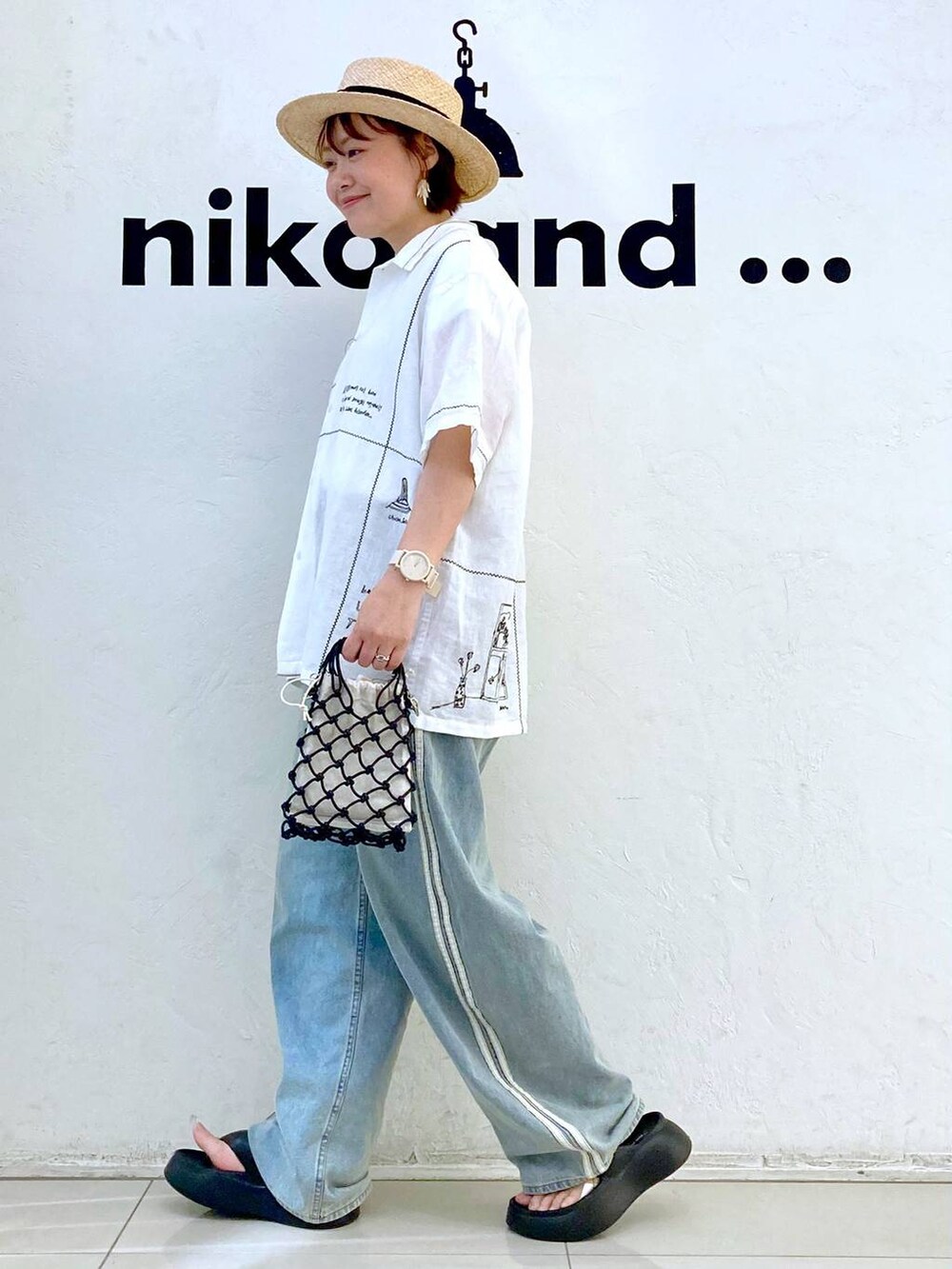 ブラック系のショルダーバッグ、ブラック系のサンダル、ホワイト系のTシャツ/カットソーを着用したレディースの春コーディネートの4枚目の写真