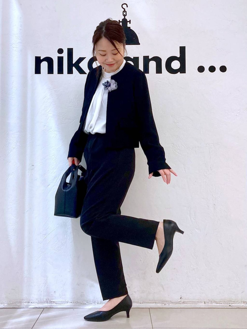 ブラック系のスーツパンツ、ホワイト系のシャツ/ブラウス、ブラック系のノーカラージャケットを着用したレディースの冬コーディネートの3枚目の写真