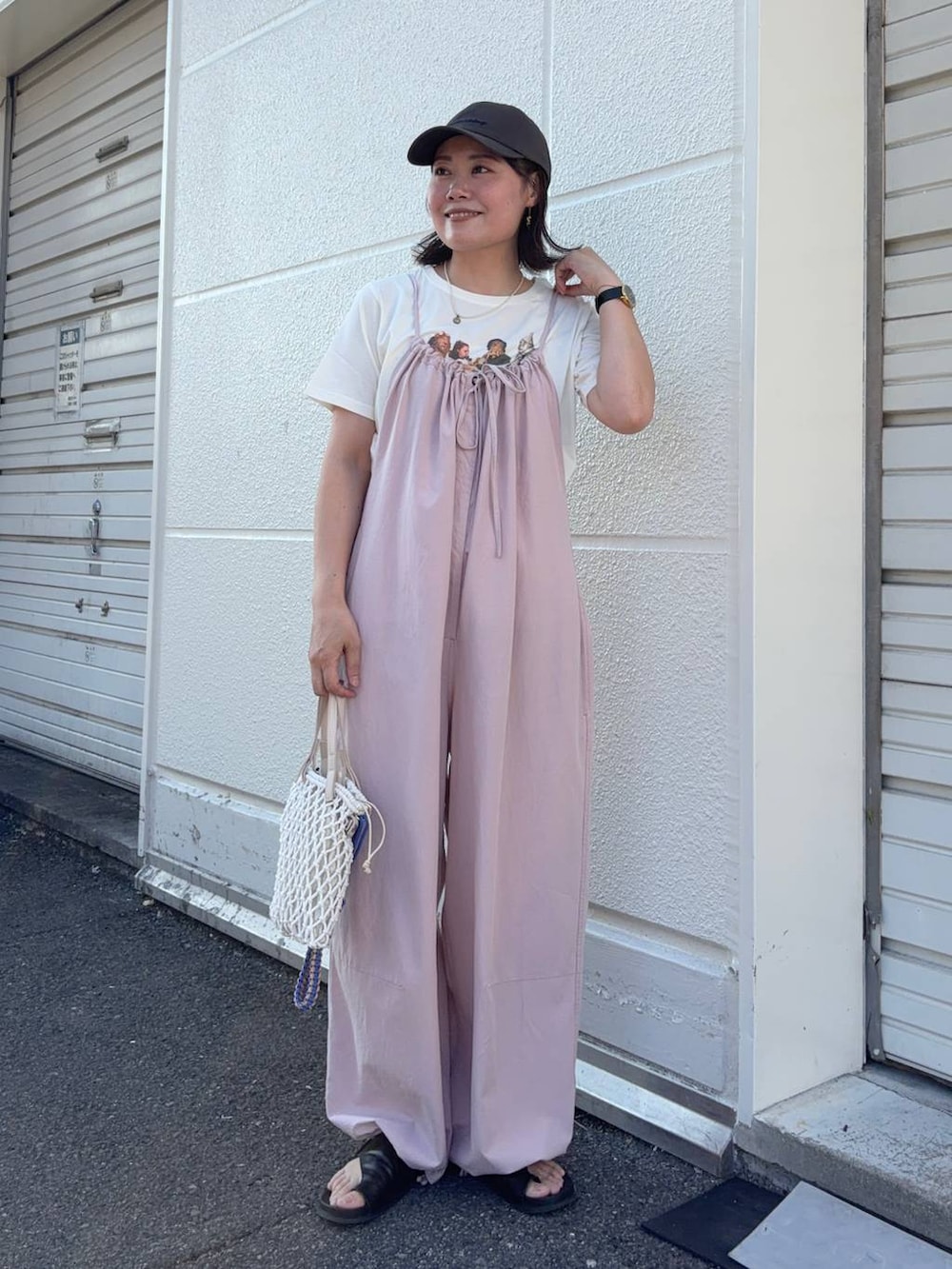 ピンク系のサロペット/オーバーオール、ベージュ系のトートバッグ、ベージュ系のTシャツ/カットソーを着用したレディースの夏コーディネートの2枚目の写真