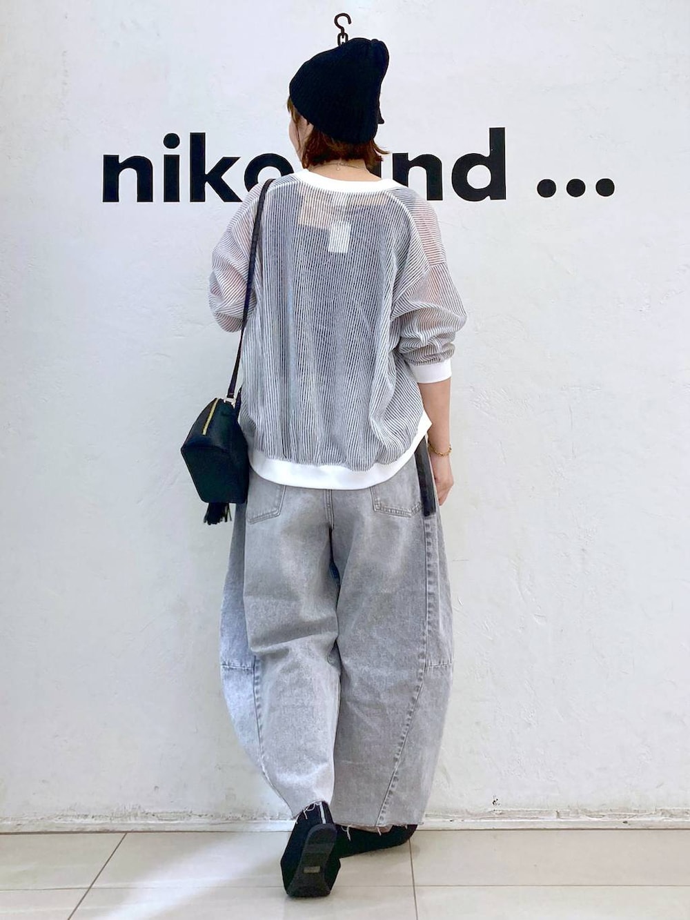 ホワイト系のカーディガン/ボレロ、グレー系のデニムパンツ、ブラック系のショルダーバッグを着用したレディースの春コーディネートの4枚目の写真