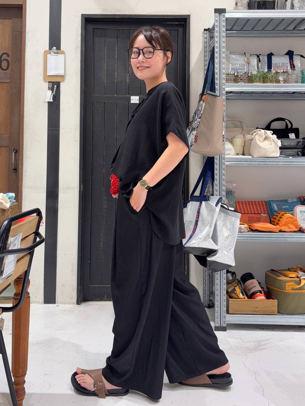レッド系のショルダーバッグ、ブラック系のシャツ/ブラウス、ブラック系のその他パンツを着用したレディースの夏コーディネートの3枚目の写真