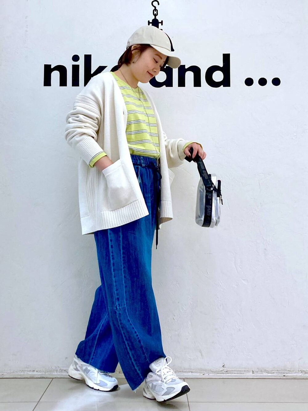 グレー系のショルダーバッグ、イエロー系のTシャツ/カットソー、ベージュ系のカーディガン/ボレロを着用したレディースの冬コーディネートの4枚目の写真