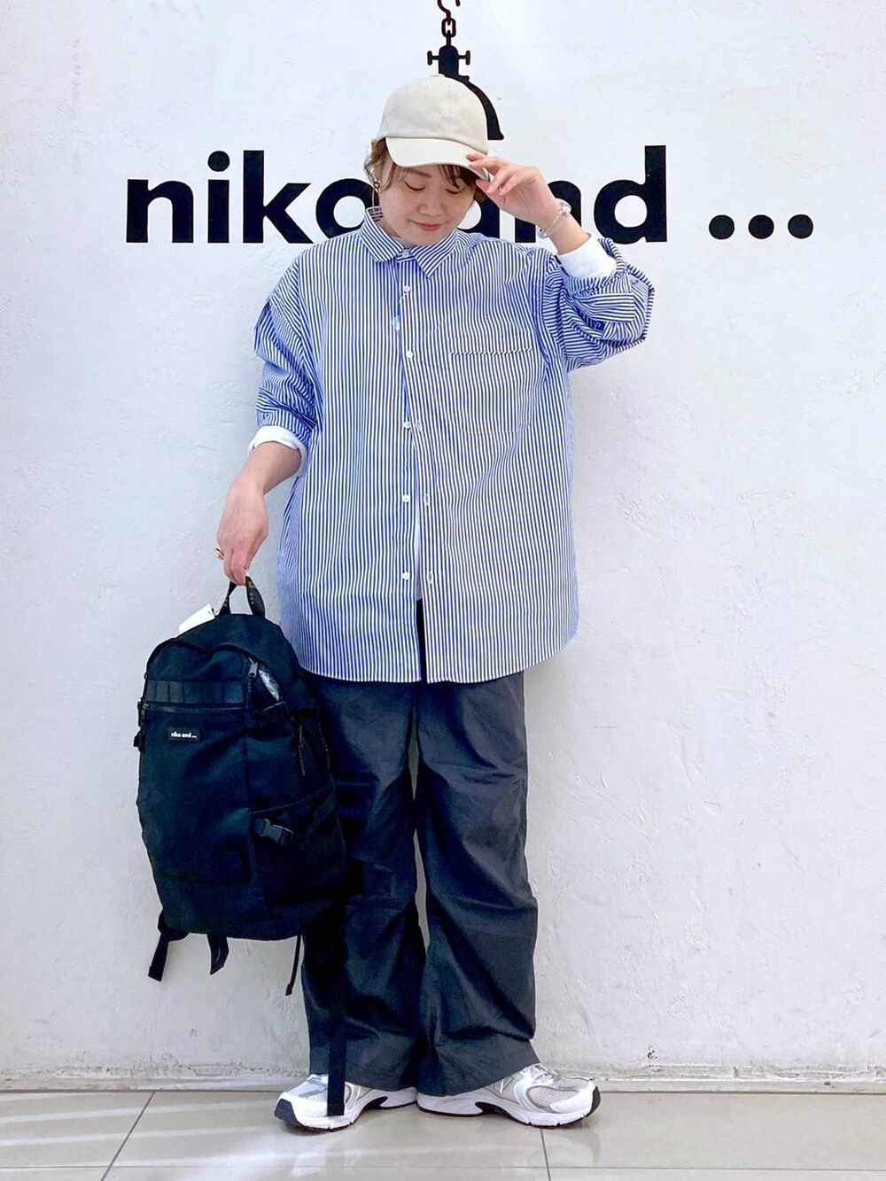 ホワイト系のTシャツ/カットソー、ブラック系のバックパック/リュック、グレー系のその他パンツを着用したレディースの春コーディネートの2枚目の写真