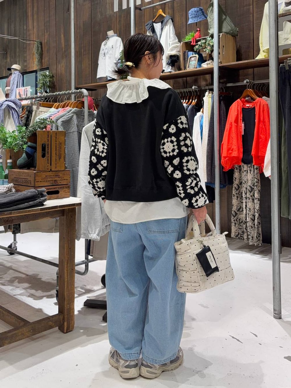 ブラック系のスウェット、ホワイト系のトートバッグ、ブルー系のその他パンツを着用したレディースの春コーディネートの3枚目の写真