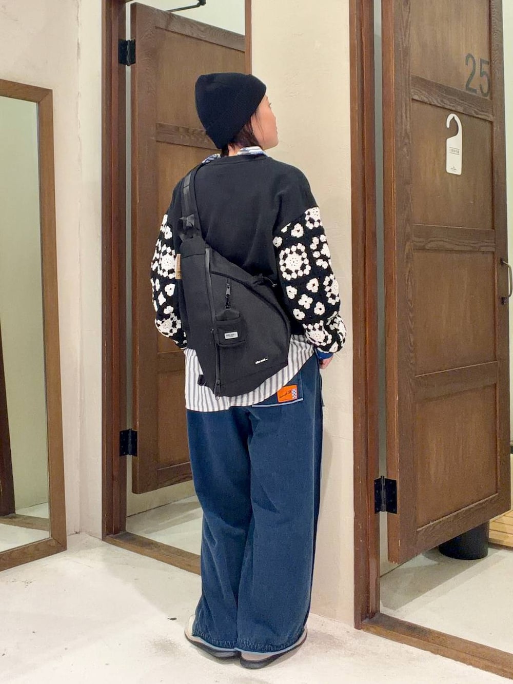 ブラック系のスウェット、ブラック系のショルダーバッグを着用したレディースの冬コーディネートの3枚目の写真