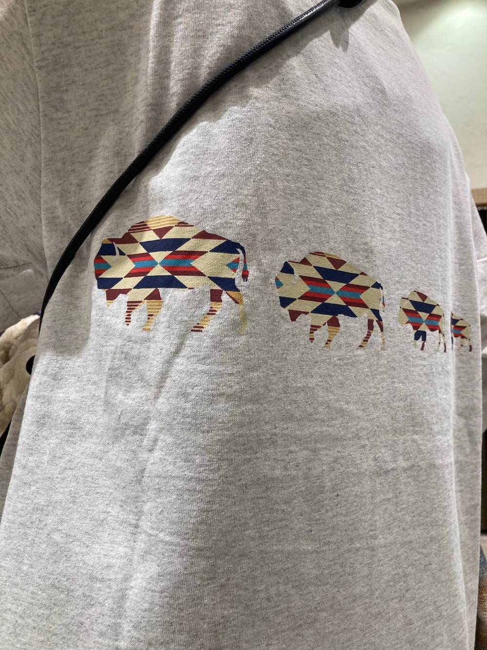 ブルー系のデニムパンツ、ブラウン系のブルゾン、ベージュ系のショルダーバッグを着用したレディースの秋コーディネートの8枚目の写真