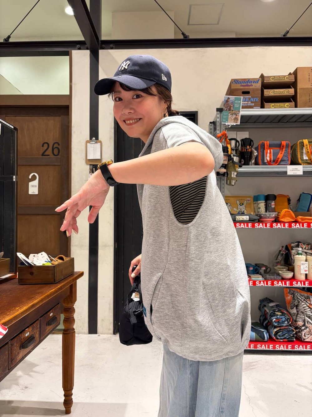 ブラック系のトートバッグ、その他のベスト、ベージュ系のTシャツ/カットソーを着用したレディースの夏コーディネートの6枚目の写真