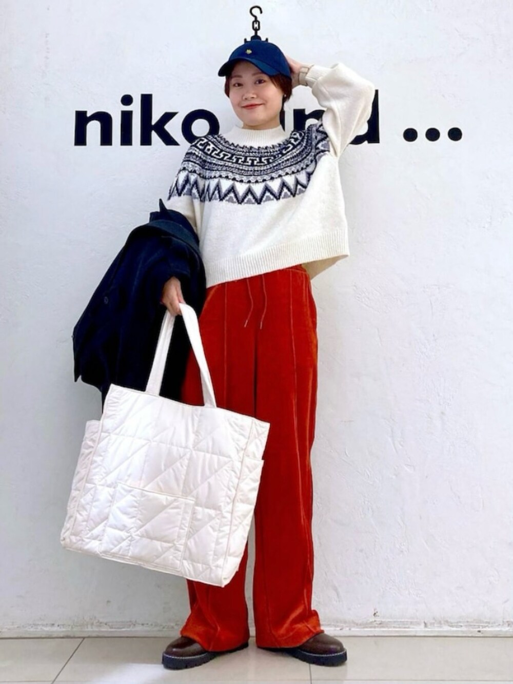 ブラック系のジャケット/アウター、ホワイト系のニット/セーター、レッド系のその他パンツを着用したレディースの冬コーディネートの3枚目の写真