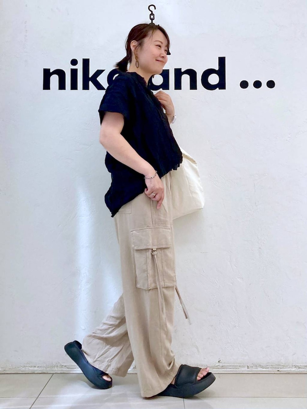 ブラック系のサンダル、ベージュ系のカーゴパンツ、ベージュ系のトートバッグを着用したレディースの夏コーディネートの5枚目の写真