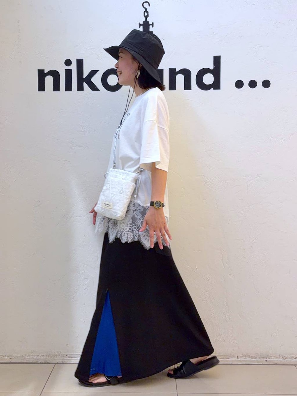 ホワイト系のショルダーバッグ、ホワイト系のTシャツ/カットソー、ブラック系のハットを着用したレディースの夏コーディネートの2枚目の写真