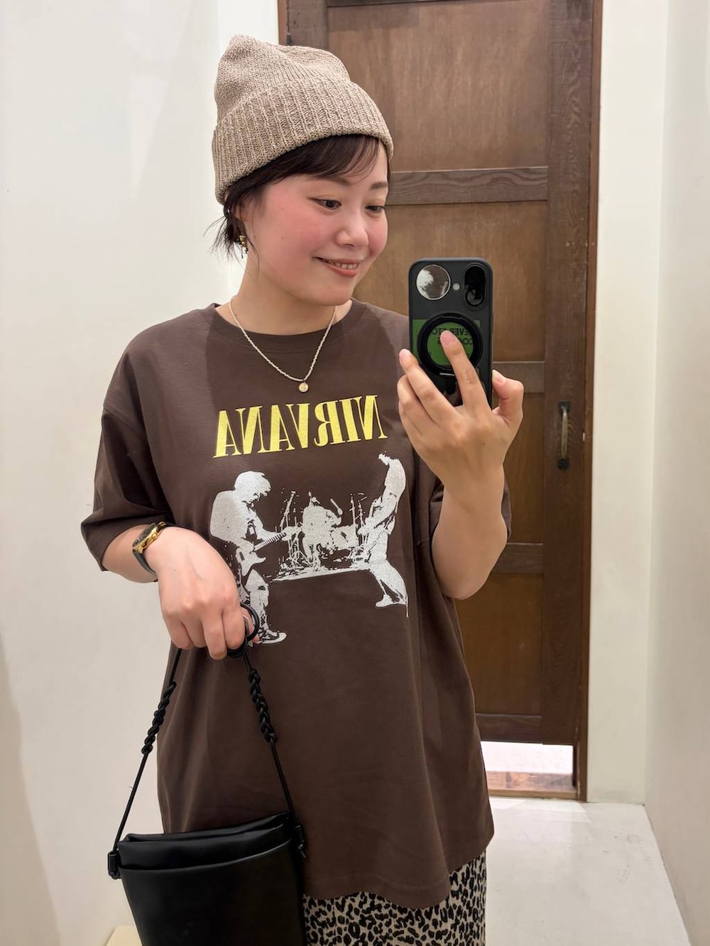 ホワイト系のスカート、ブラック系のショルダーバッグ、ブラウン系のTシャツ/カットソーを着用したレディースの夏コーディネートの2枚目の写真