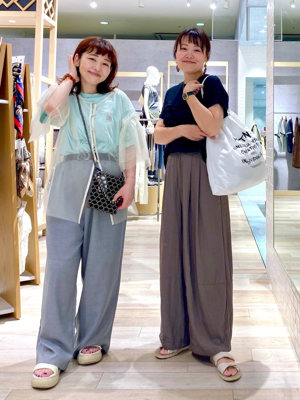 ブラック系のショルダーバッグ、ホワイト系のTシャツ/カットソー、ブラック系のTシャツ/カットソーを着用したレディースの夏コーディネートの3枚目の写真