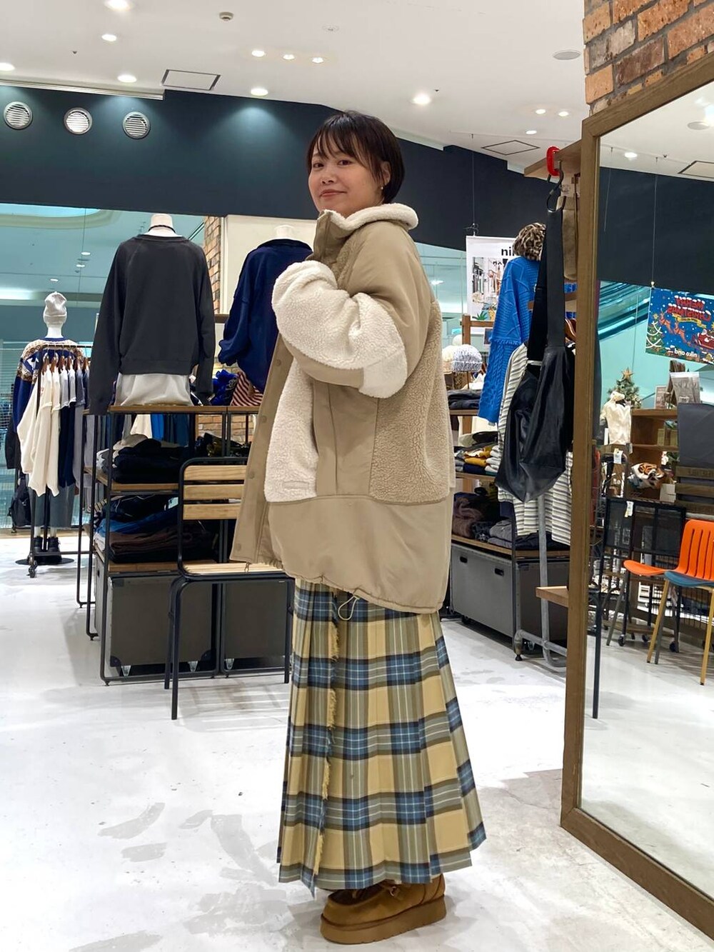 ホワイト系のショルダーバッグ、イエロー系のモカシン/デッキシューズ、ベージュ系のその他アウターを着用したレディースの秋コーディネートの3枚目の写真