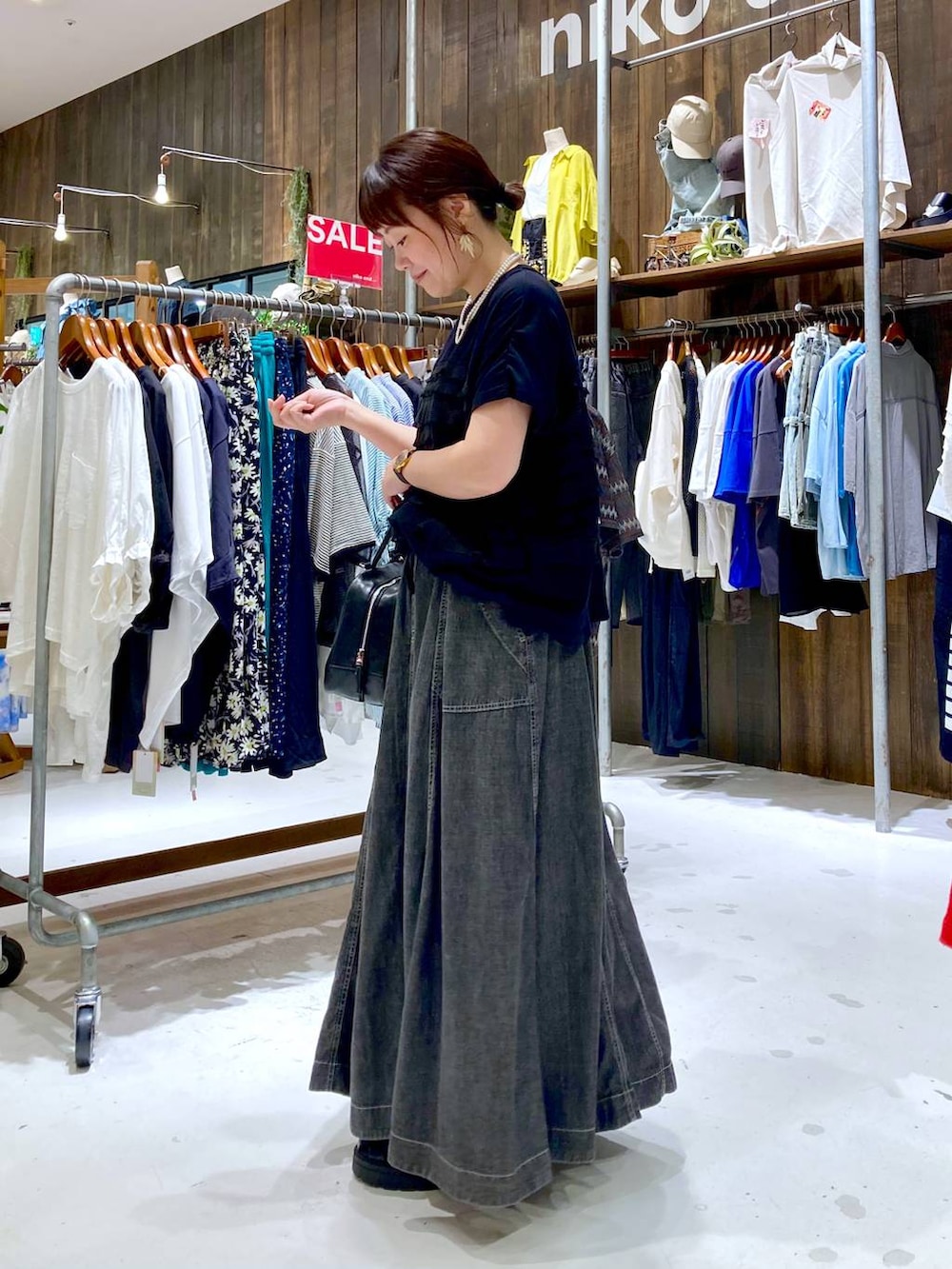 グレー系のスカート、ブラック系のボストンバッグ、ブラック系のTシャツ/カットソーを着用したレディースの夏コーディネートの3枚目の写真