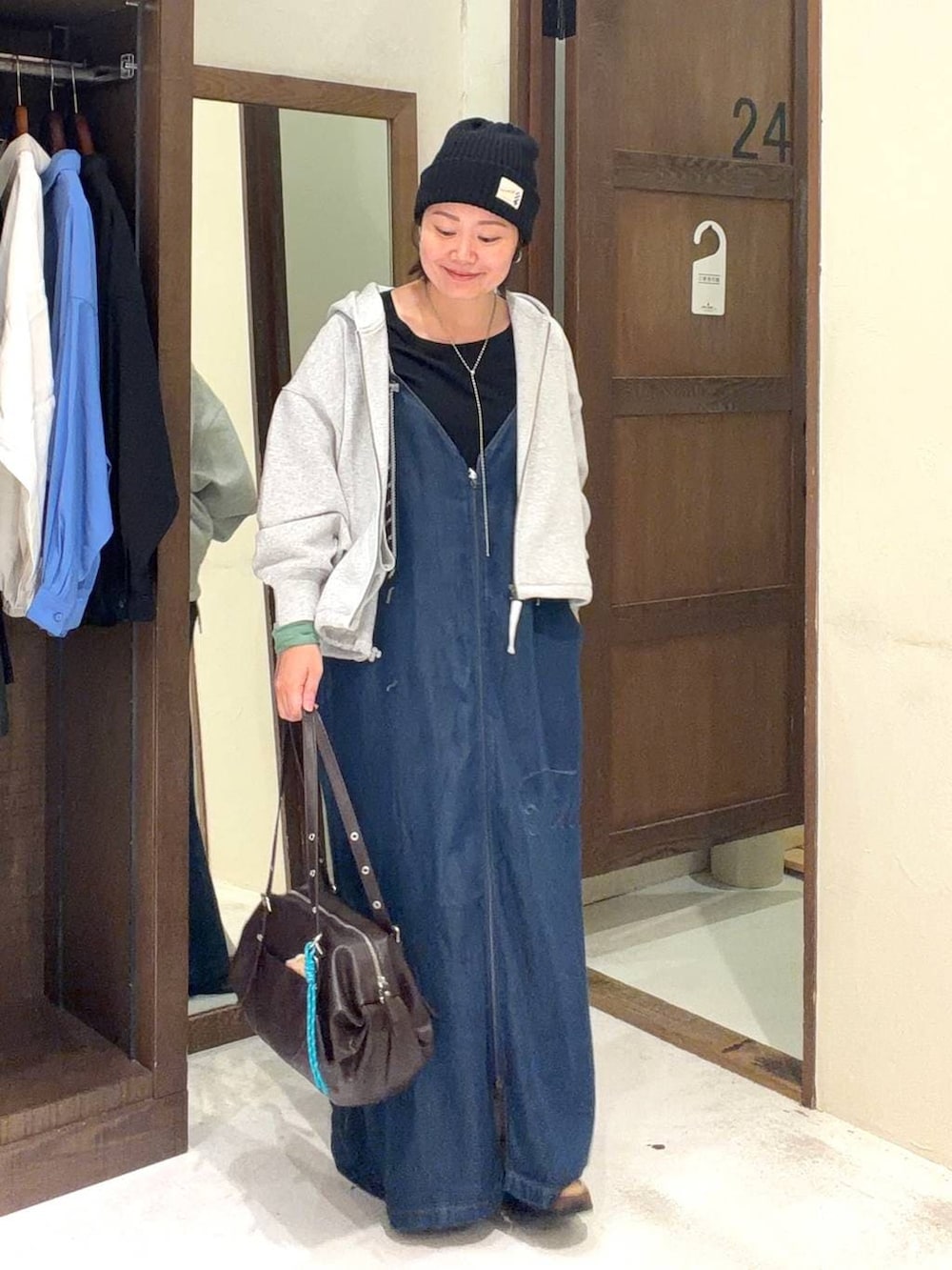 ブラウン系のボストンバッグ、ブラック系のTシャツ/カットソー、グレー系のパーカーを着用したレディースの春コーディネートの2枚目の写真