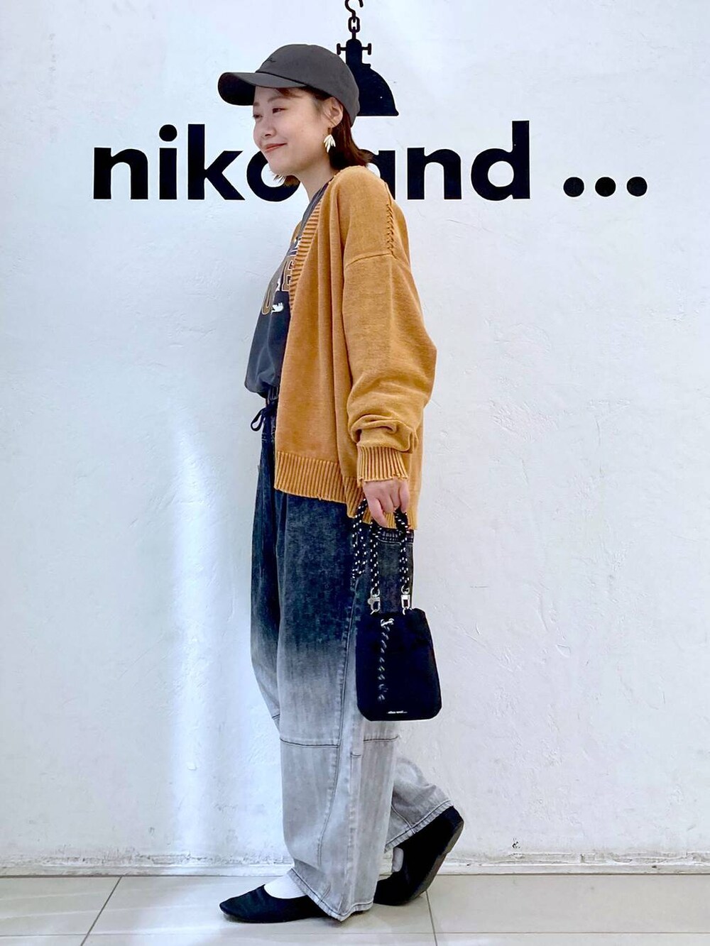 ブラック系のショルダーバッグ、グレー系のTシャツ/カットソー、ブラック系のデニムパンツを着用したレディースの秋コーディネートの3枚目の写真