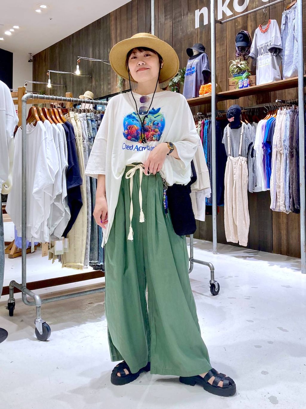 グリーン系のその他パンツ、ブラック系のショルダーバッグ、ホワイト系のTシャツ/カットソーを着用したレディースの夏コーディネートの2枚目の写真