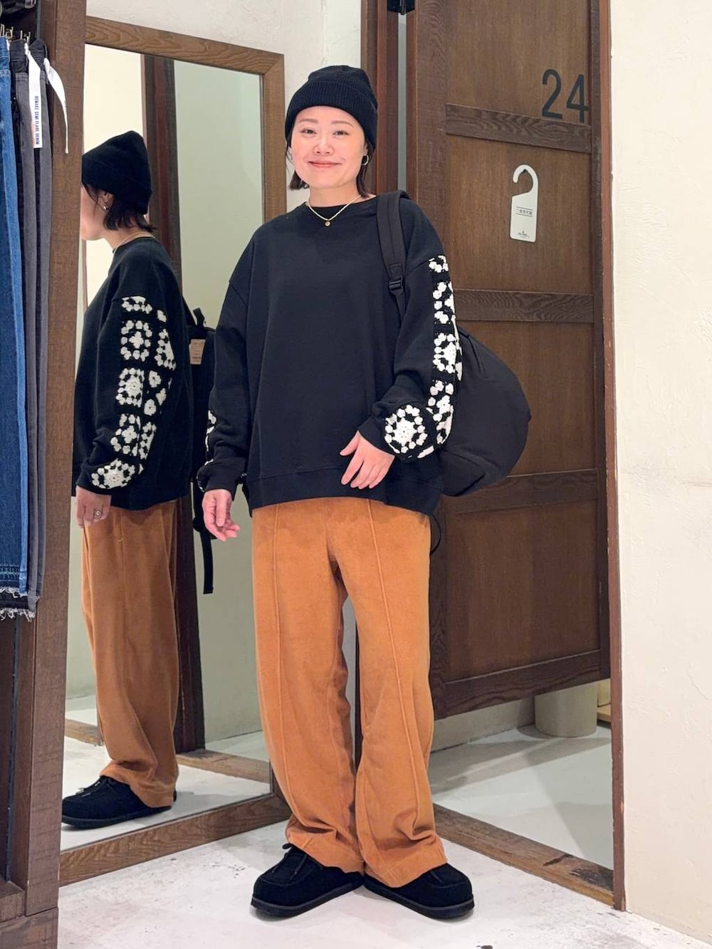 ブラック系のスウェット、オレンジ系のその他パンツ、ブラック系のモカシン/デッキシューズを着用したレディースの春コーディネートの4枚目の写真