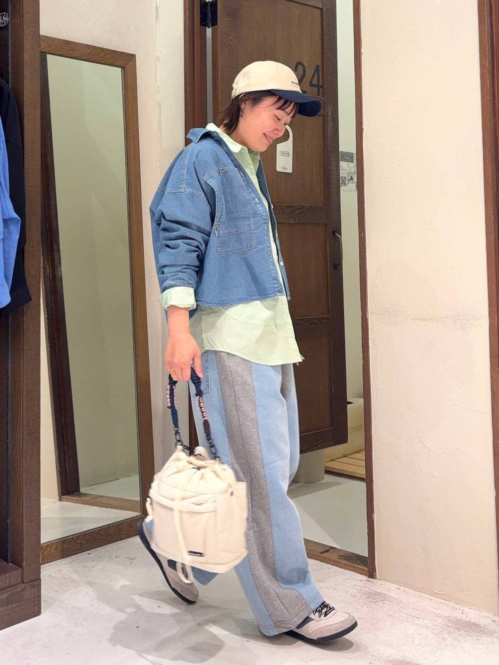 グレー系のデニムパンツ、グリーン系のシャツ/ブラウス、ベージュ系のショルダーバッグを着用したレディースの春コーディネートの3枚目の写真