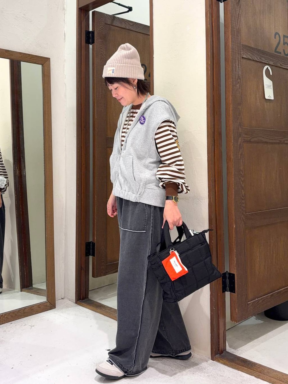ブラック系のトートバッグ、グレー系のベストを着用したレディースの冬コーディネートの5枚目の写真