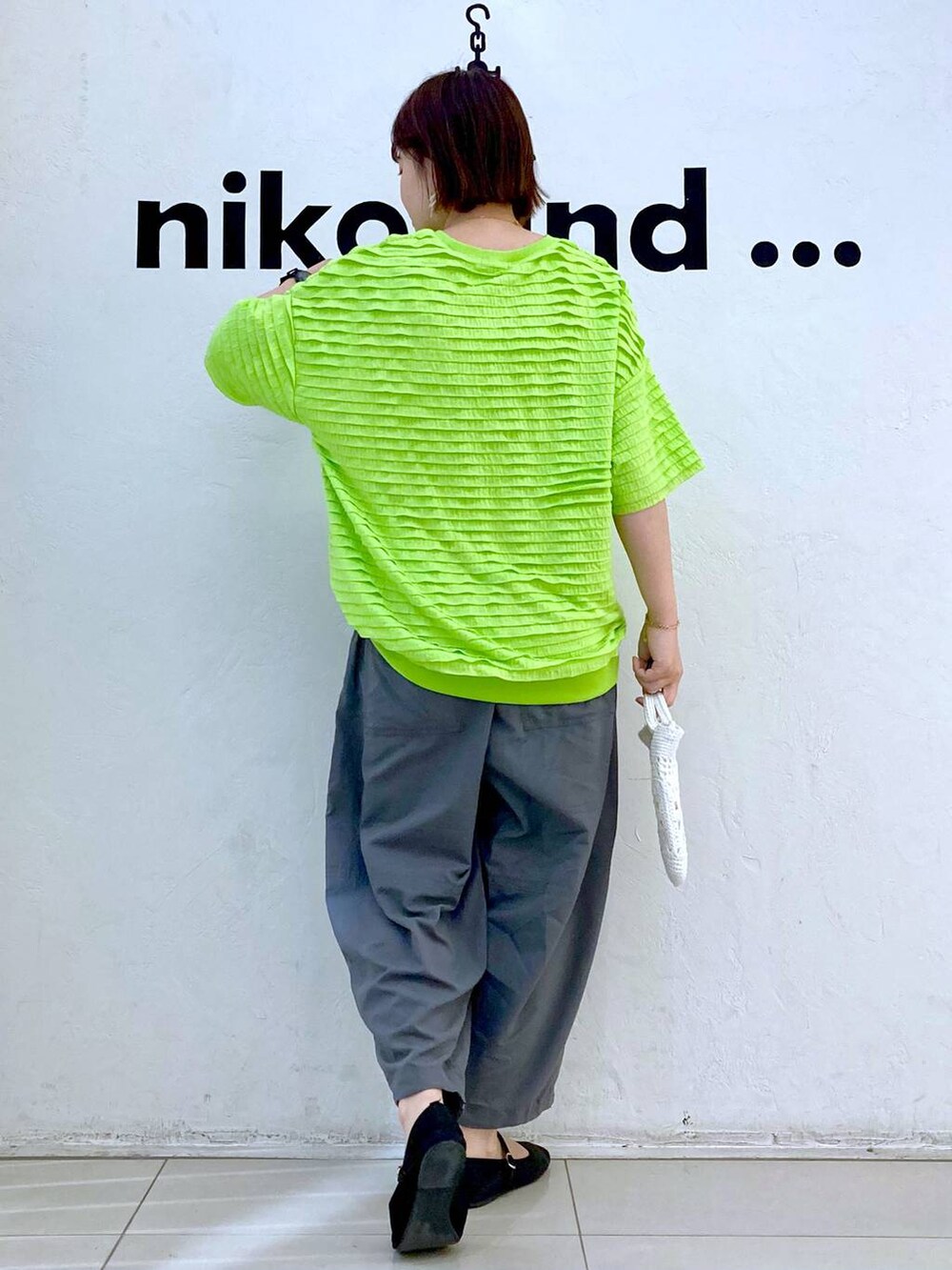 ホワイト系のショルダーバッグ、グリーン系のTシャツ/カットソー、グレー系のその他パンツを着用したレディースの春コーディネートの4枚目の写真