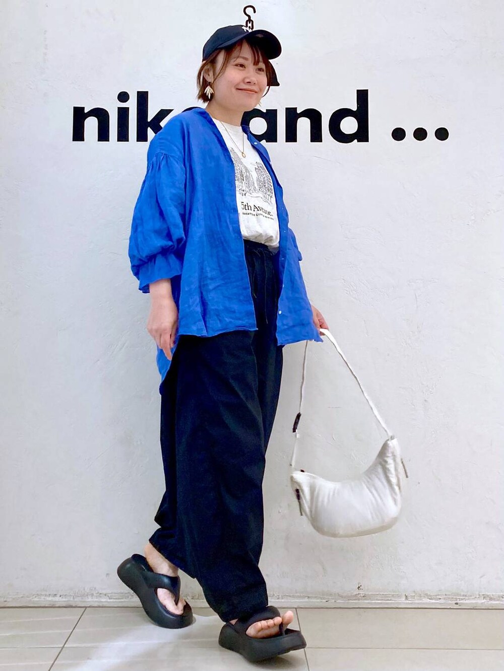 ブラック系のサンダル、ベージュ系のTシャツ/カットソー、ホワイト系のショルダーバッグを着用したレディースの春コーディネートの3枚目の写真