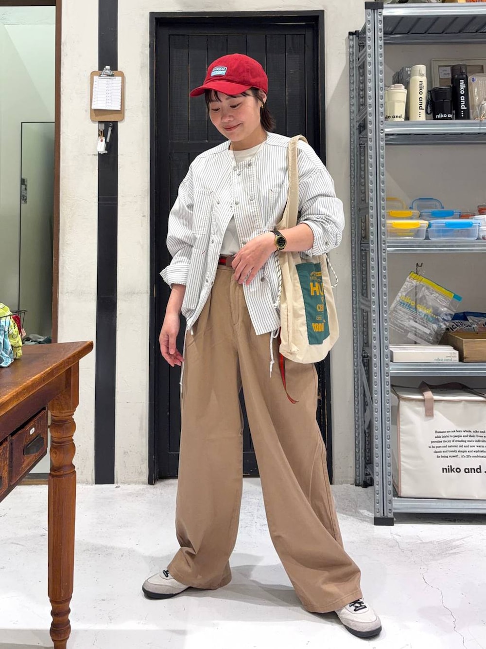 ホワイト系のトートバッグ、ベージュ系のカバーオール、ホワイト系のTシャツ/カットソーを着用したレディースの春コーディネートの2枚目の写真